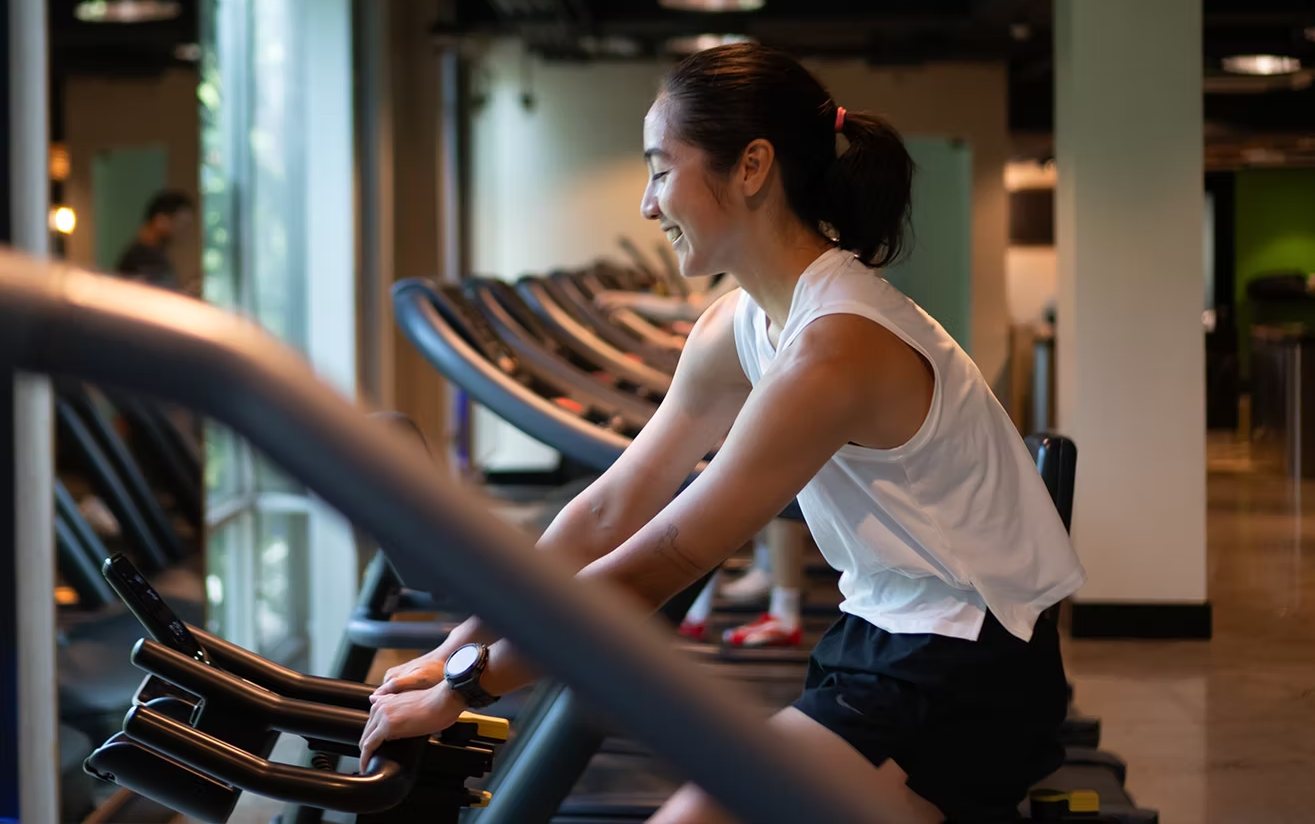 A member laughing mid-session on the cardio floor at Rockwell Atletica.